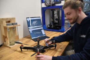 Eine selbstgebaute Drohne auf einer Arbeitsfläche wird untersucht.