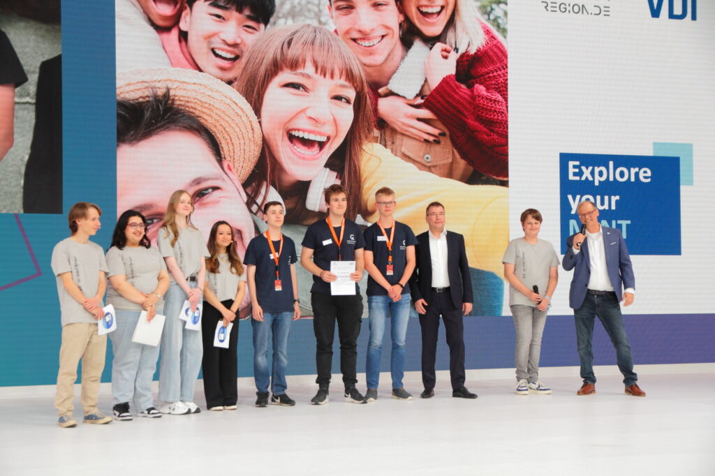 Die zweitplatzierten mit dem Projekt „Wattamaran“ vom Berufsbildenden Gymnasium Georg-von-Langen-Schule in Holzminden und den Moderatoren auf der Bühne der Ideen Expo.